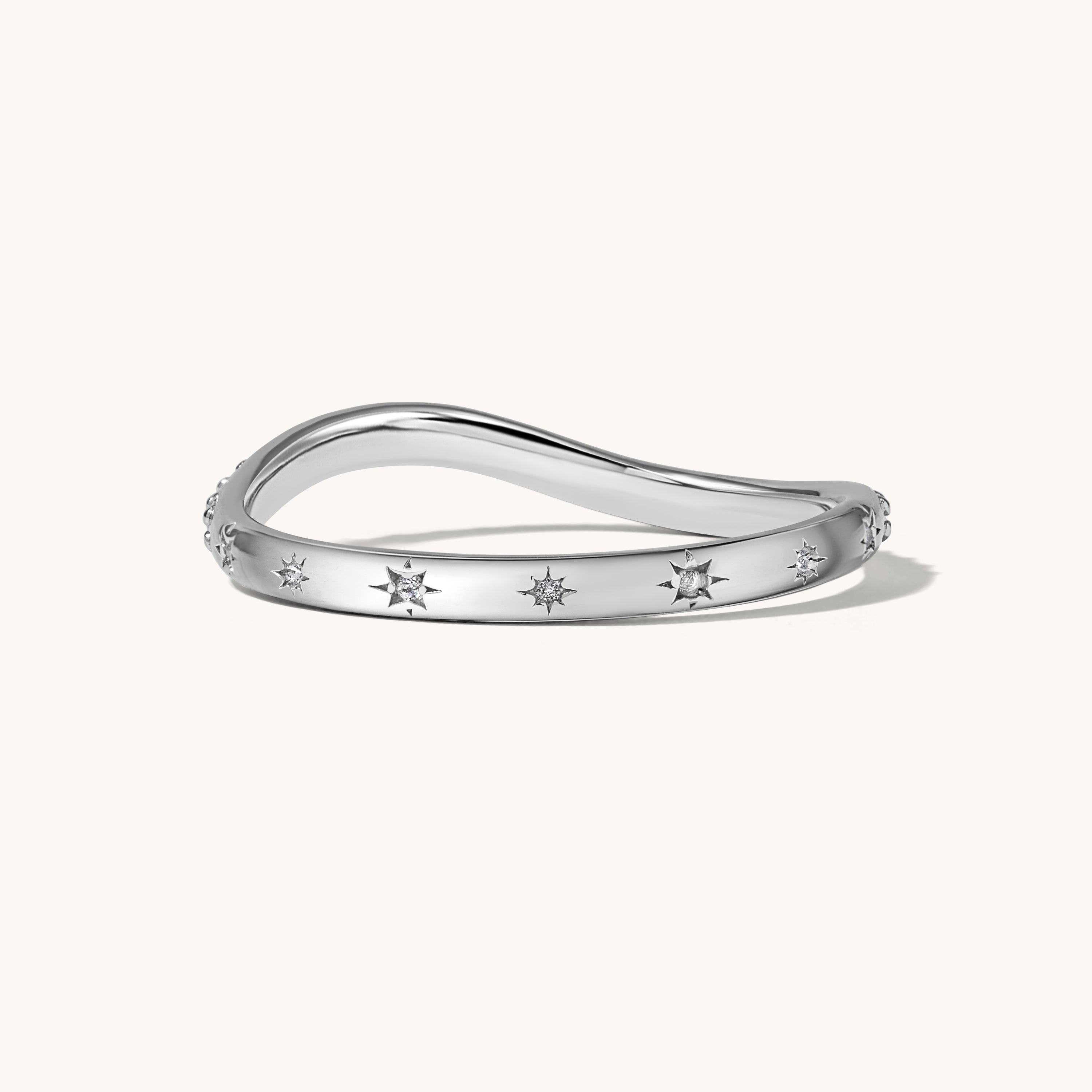 Silver ring with small white starburst stones on a white background
