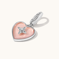 Heart-shaped pendant with pink center and silver accents on a white background