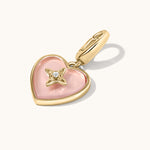 Heart-shaped pendant with pink rose quartz and gold accents on a white background