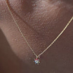 Woman wearing flower pendant necklace and touching it.