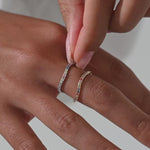 Woman putting on colored gemstone ring set in gold and silver.